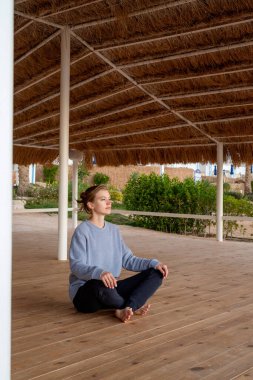 Güneş doğarken pratik Yoga sahilde genç sağlıklı kadın