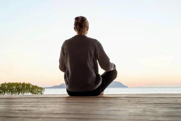 Güneş doğarken pratik Yoga sahilde genç sağlıklı kadın — Stok fotoğraf