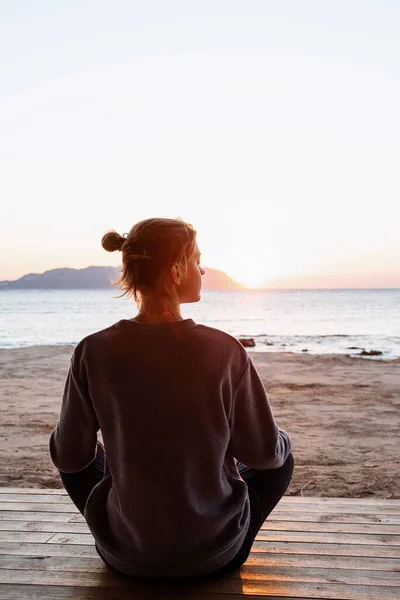 Güneş doğarken pratik Yoga sahilde genç sağlıklı kadın — Stok fotoğraf