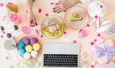 Doğum günü partisi. Doğum günü masaları. Kadın doğum gününü arkadaşlarıyla görüntülü konuşma yaparak kutluyor.