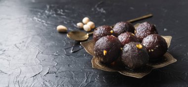 Geleneksel Hint tatlıları. Tatlı Gulab Jamun siyah zemin üzerinde metal plaka