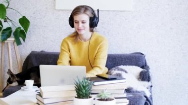 Mesafe öğrenme. E-öğrenme. İş için. Genç bir kadın internette dizüstü bilgisayar sohbeti yapıyor, video görüşmesi yapıyor ve kahve içiyor.