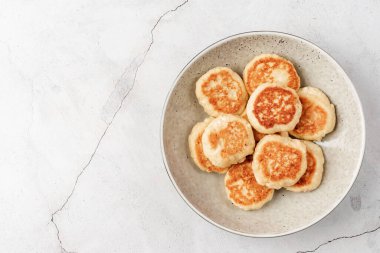Çimento kaplamalı seramik tabakta süzme peynirli börek. Sağlıklı kalsiyum kahvaltı, öğle yemeği veya atıştırmalık. Geleneksel Rus yemekleri. Kapat.