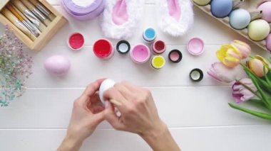 Üst düzey kadın elleri mutfakta oturan yumurtaları boyuyor, merhaba bahar konsepti, Paskalya hazırlığı konsepti