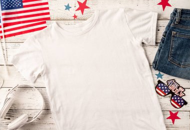 ABD Anma Günü, Başkanlar Günü, Gaziler Günü, İşçi Bayramı ya da 4 Temmuz kutlamaları. Logo için polo tişörtü, Amerikan bayrağı, ayakkabısı ve kotuyla beyaz ahşap arka planda üst görünüm