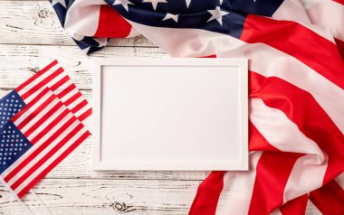 ABD Anma Günü, Başkanlar Günü, Gaziler Günü, İşçi Bayramı ya da 4 Temmuz kutlamaları. Amerikan ulusal bayrağının ahşap arka planında model tasarımı için boş beyaz fotoğraf çerçevesi