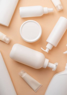 Eco friendly shopping and living.Group of white blank packaging tubes and containers for cosmetics on beige natural color background, mockup design, eco friendly top view