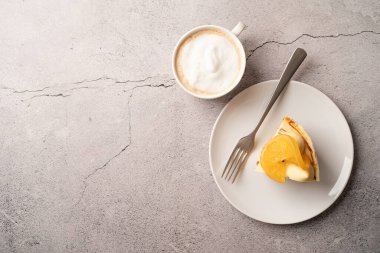 Vegan homemade carrot cake with orangewith cup of coffee on concrete background, copy space