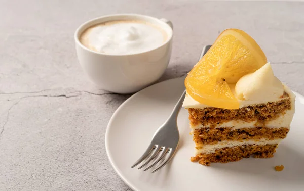 Vegan homemade carrot cake with orangewith cup of coffee on concrete background, copy space