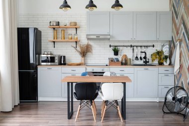 Mutfağın içi eski mutfak gereçleri ve ahşap duvarlarla kırsal tarzda.