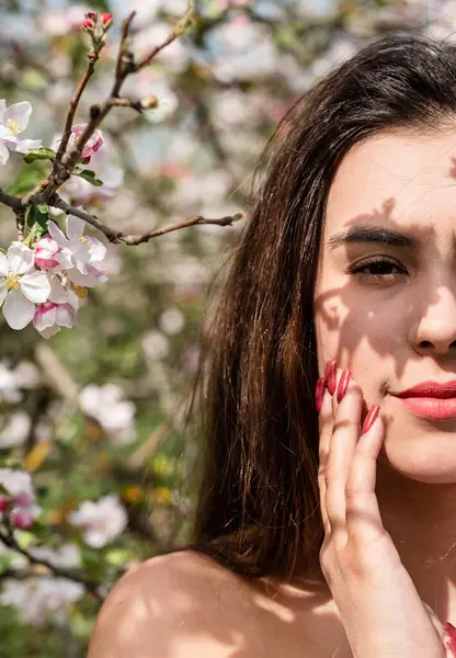 Spring concept. Nature.Young caucasian woman enjoying the flowering of an apple trees, walking in spring apple gardens