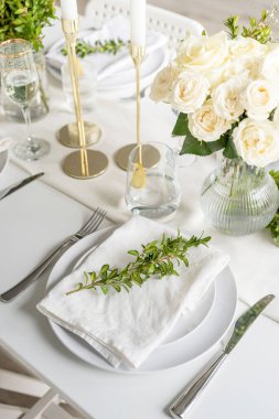 Wedding table set up in taditional style with roses grass and greenery. Wedding table scapes