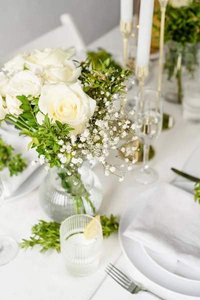 Wedding table set up in taditional style with roses grass and greenery. Wedding table scapes