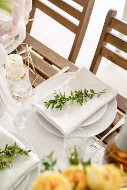 The wedding table setting and decor on wooden table in rustic style. Wedding table scapes. Table set up with boxwood and amaryllis flowers