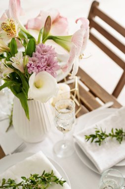 The wedding table setting and decor on wooden table in rustic style. Wedding table scapes. Table set up with boxwood and amaryllis flowers