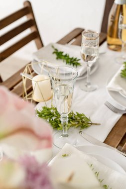 The wedding table setting and decor on wooden table in rustic style. Wedding table scapes. Table set up with boxwood and amaryllis flowers