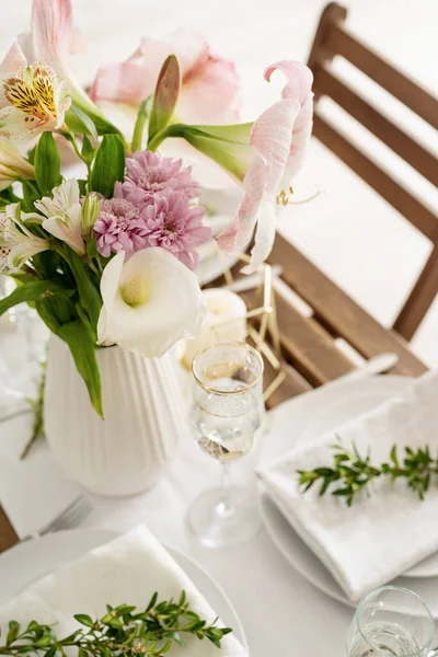 The wedding table setting and decor on wooden table in rustic style. Wedding table scapes. Table set up with boxwood and amaryllis flowers