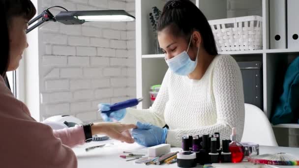 Manicure fazendo uma manicure no salão. Mestre servindo seu cliente. Procedimento de cuidado unhas . — Vídeo de Stock