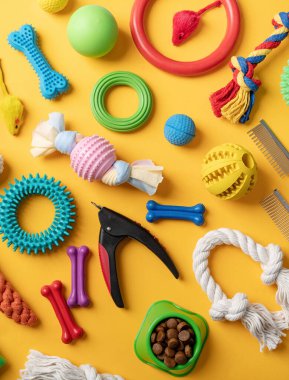 Pet care concept, various pet accessories and tools, toys, balls, brushes on yellow background, flat lay pattern