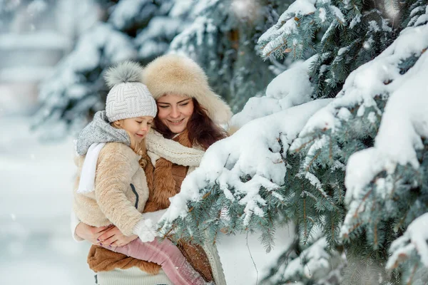 戴帽子的女孩和母亲在寒冷的冬日玩耍. — 图库照片