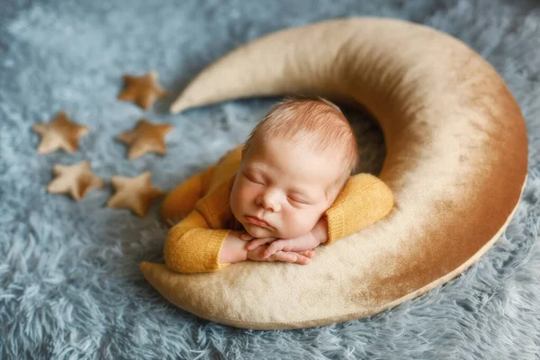 Bebê recém-nascido está dormindo em uma lua em forma de suporte posando. — Fotografia de Stock