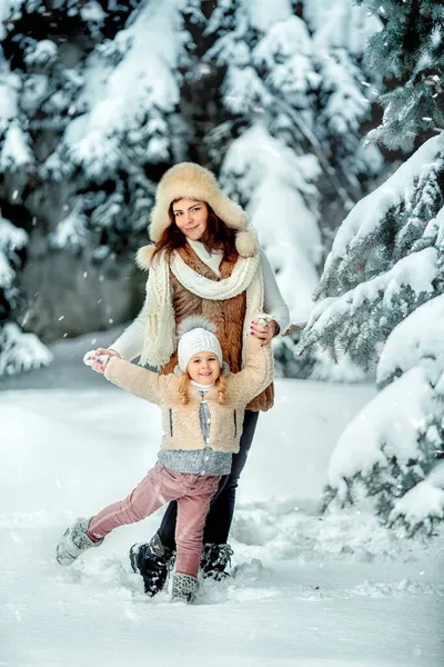 可爱的小女孩和她的妈妈在雪天玩耍 — 图库照片