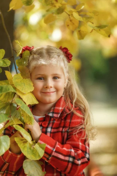 Piccola ragazza bionda al parco autunnale. — Foto Stock