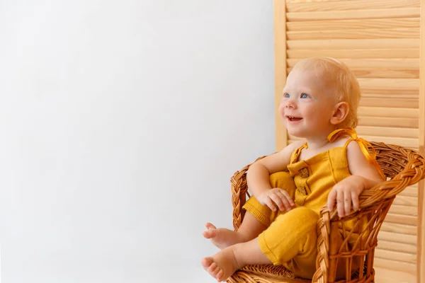 Baby jongen zittend op de houten fauteuil en glimlachend. — Stockfoto