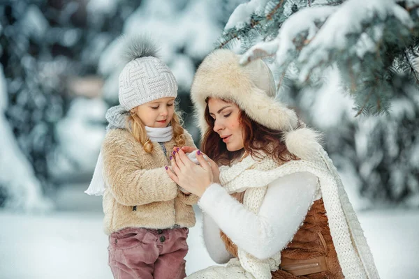 女孩和母亲在雪天玩耍 — 图库照片