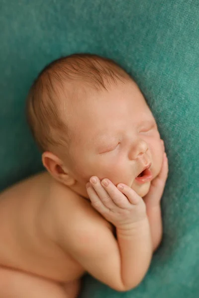 Alvó újszülött, zöld háttérrel — Stock Fotó