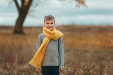 Gri fırtınalı sonbahar gününde ayakta duran çocuk.