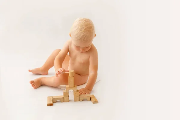 Kleine jongen spelen met houten bouwstenen. — Stockfoto