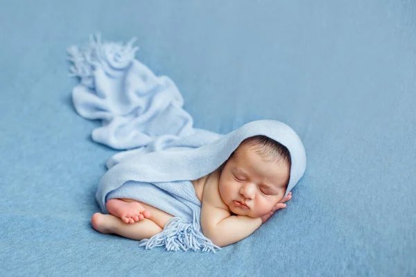 Novorozeně dítě na modrém pozadí pokryté přikrývkou. — Stock fotografie