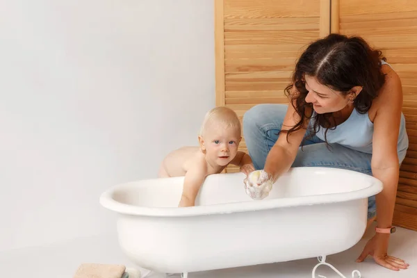Мать стирает маленький сын в ванной комнате. — стоковое фото
