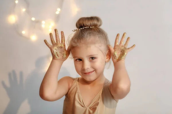 Mutlu mutlu kız ellerini tutuyor ve altın parıltısını gösteriyor.. 