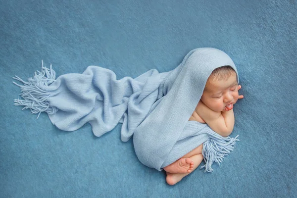 Újszülött, kék hátterű, takaróval borított. — Stock Fotó