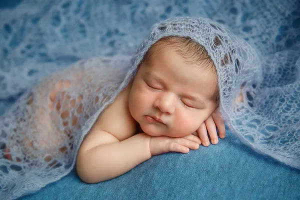 Bebê recém-nascido adormecido em um fundo azul coberto por cobertor. — Fotografia de Stock