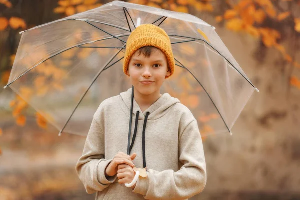 투명 한 우산을 두른 모자를 쓴 소년 — 스톡 사진
