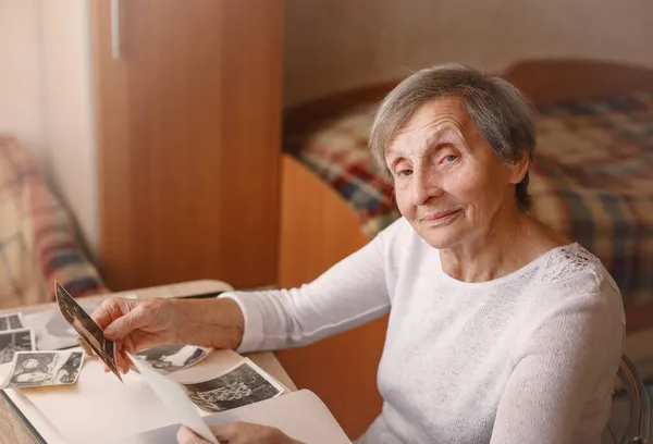 Donna anziana è alla ricerca di foto d'epoca. — Foto Stock