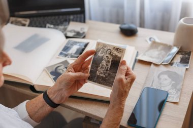 Yaşlı kadın eski fotoğraflara bakıyor..