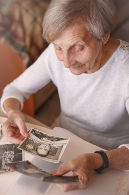 Yaşlı kadın kendi eski fotoğraflarını izliyor..