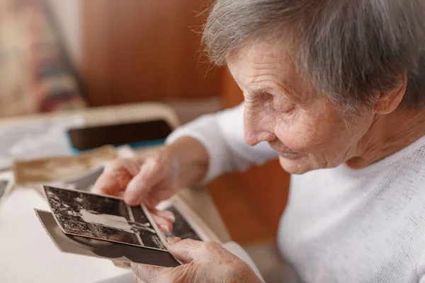 Az idősebb nő a saját régi képeit nézi.. — Stock Fotó