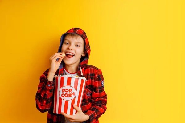Szczęśliwy chłopiec zostaje z wiadrem popcornu. — Zdjęcie stockowe
