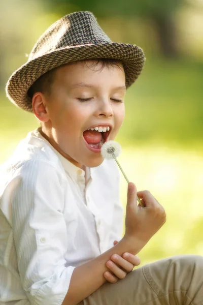 Boy is eating dandelion — Stock Photo, Image