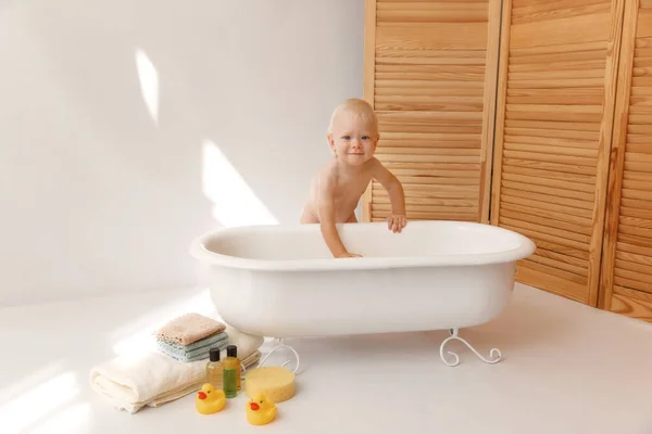 Bañar al bebé en baño blanco con patos de goma — Foto de Stock