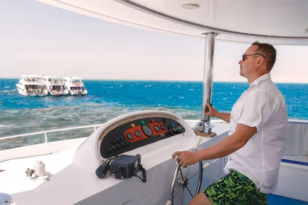 Yatın dümeninde bir adam var.