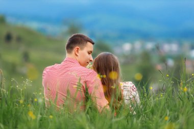  Mutlu çift birlikte oturup doğaya bakıyor, iki insan sakin anların tadını çıkarıyor. Genç adam karısına bakıyor. Arka plan