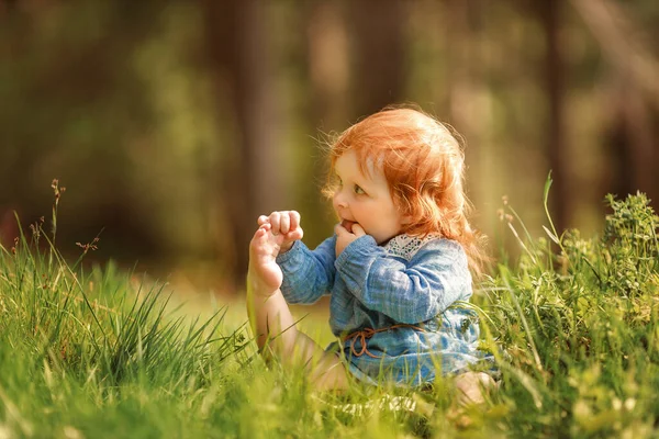 Funny Red Hair Baby Sitting Grass Holding Her Own Leg — Stockfoto