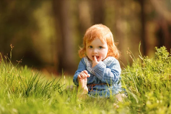 Funny Red Hair Baby Sitting Grass Holding Her Own Leg — 图库照片