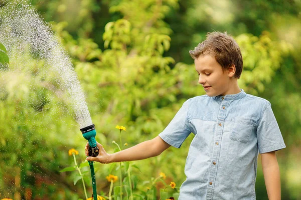 Boy Watering Flower Garden Kid Pours Water Hose Summer Day — Stok Foto